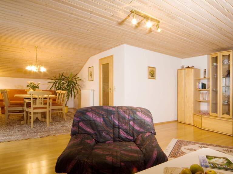 Wohnzimmer in einer Ferienwohnung von Riedl Reisen mit Holzmöbeln und gemütlicher Einrichtung